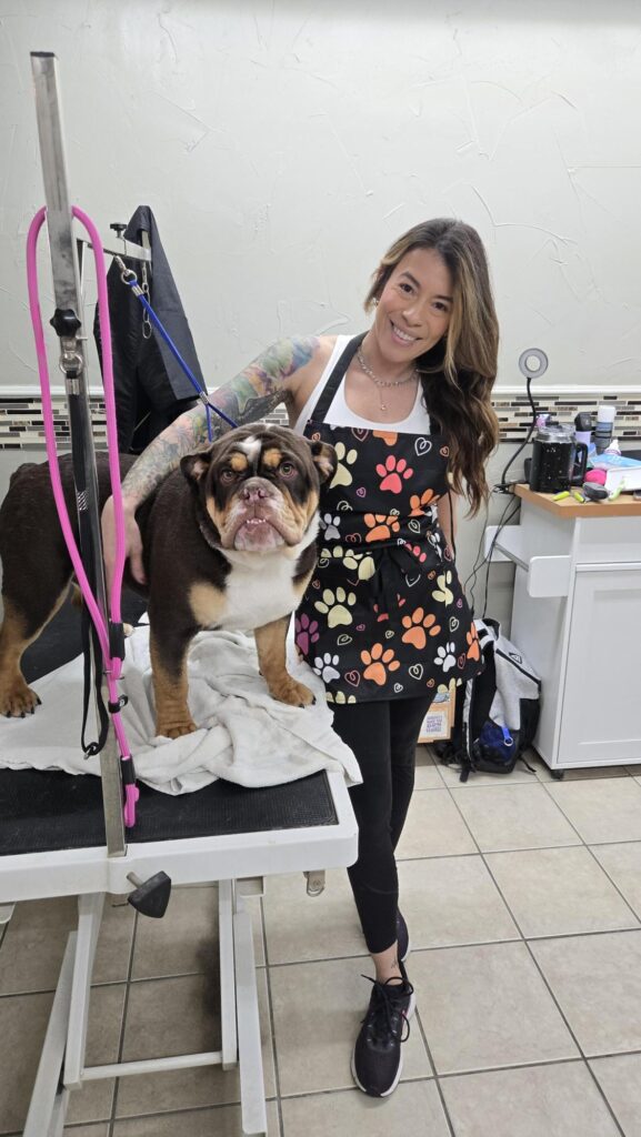 Groomer with a small dog after its appointment